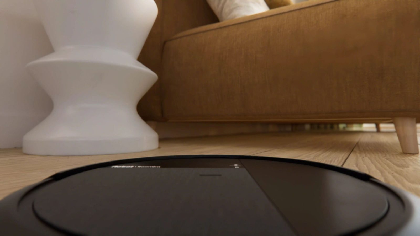 A Roomba&reg; robot cleaning underneath a sofa