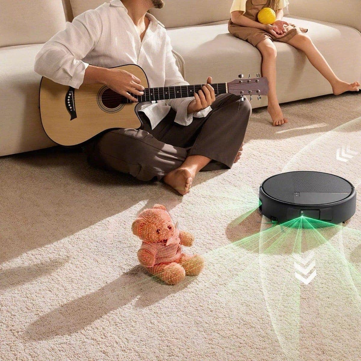 Roomba&reg; Max 875 Combo robot steering around a toy on the floor while a parent and child play guitar on the sofa